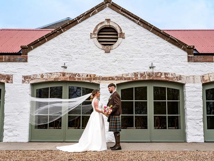 Bride and groom in front of Kinclune Steading